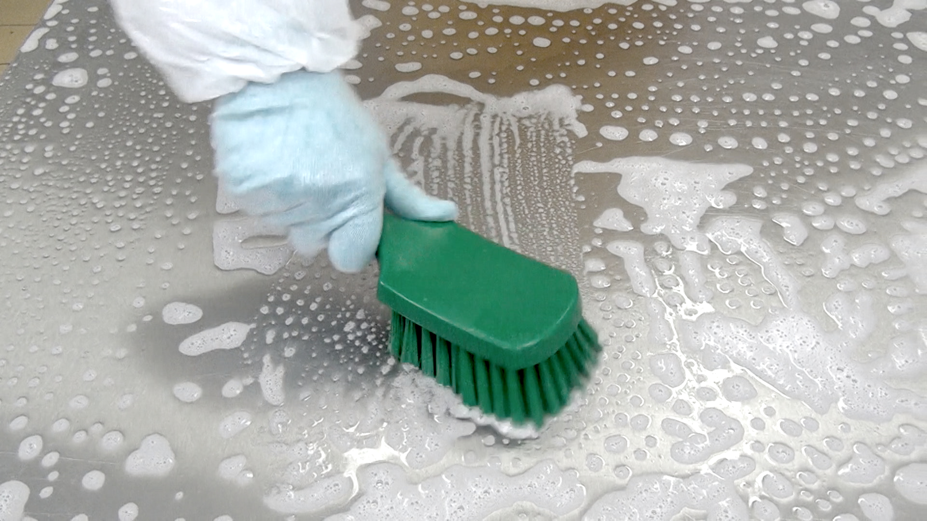 Easy Sanitization eine Person, die eine Oberfläche mit einer grünen Bürste reinigt