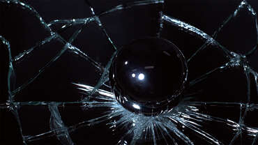 Impactinator® زجاج - زجاج يقوي كرة زجاجية على سطح أسود