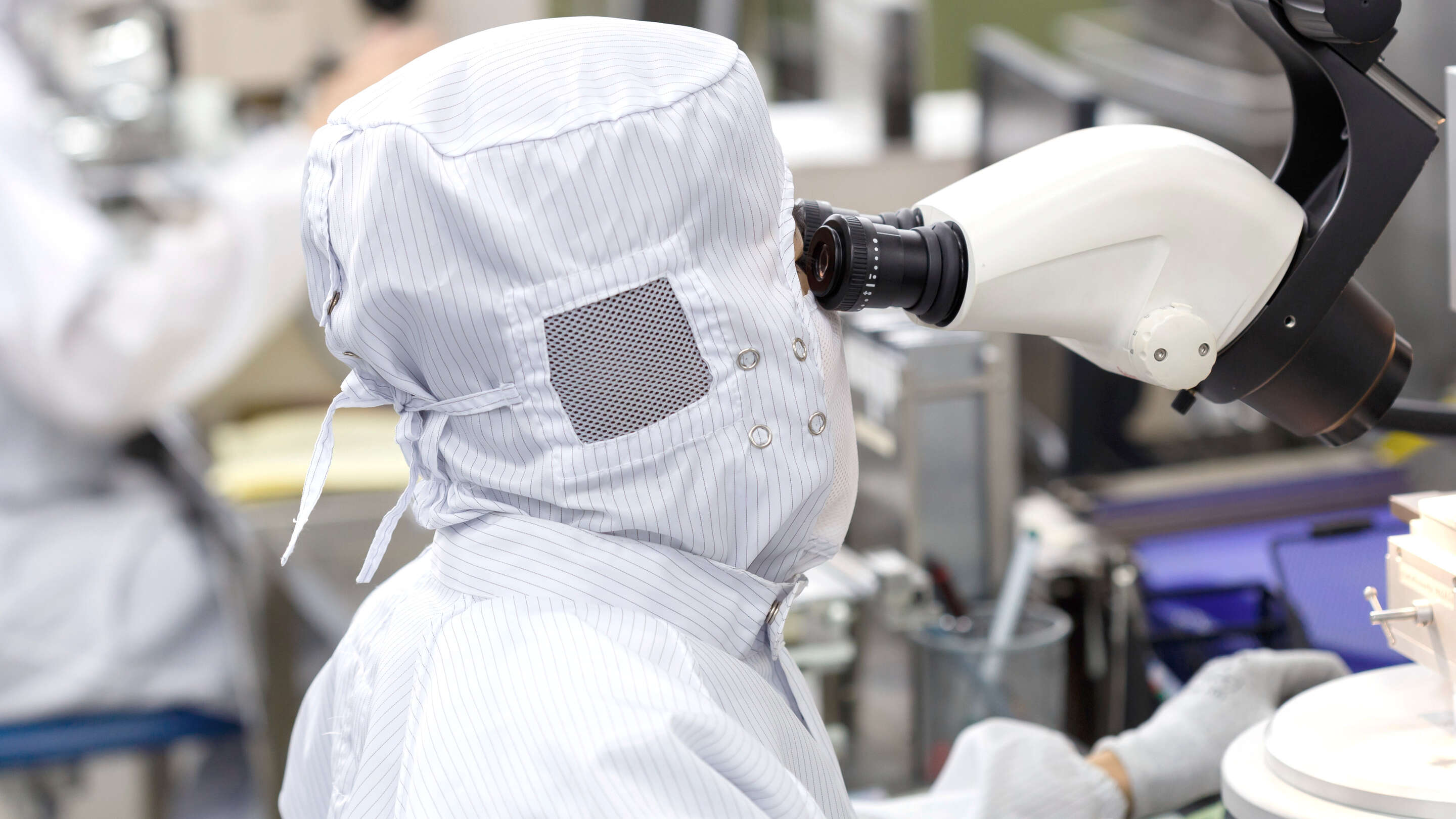 Manufacturing - Processes a person wearing a white suit and a white mask