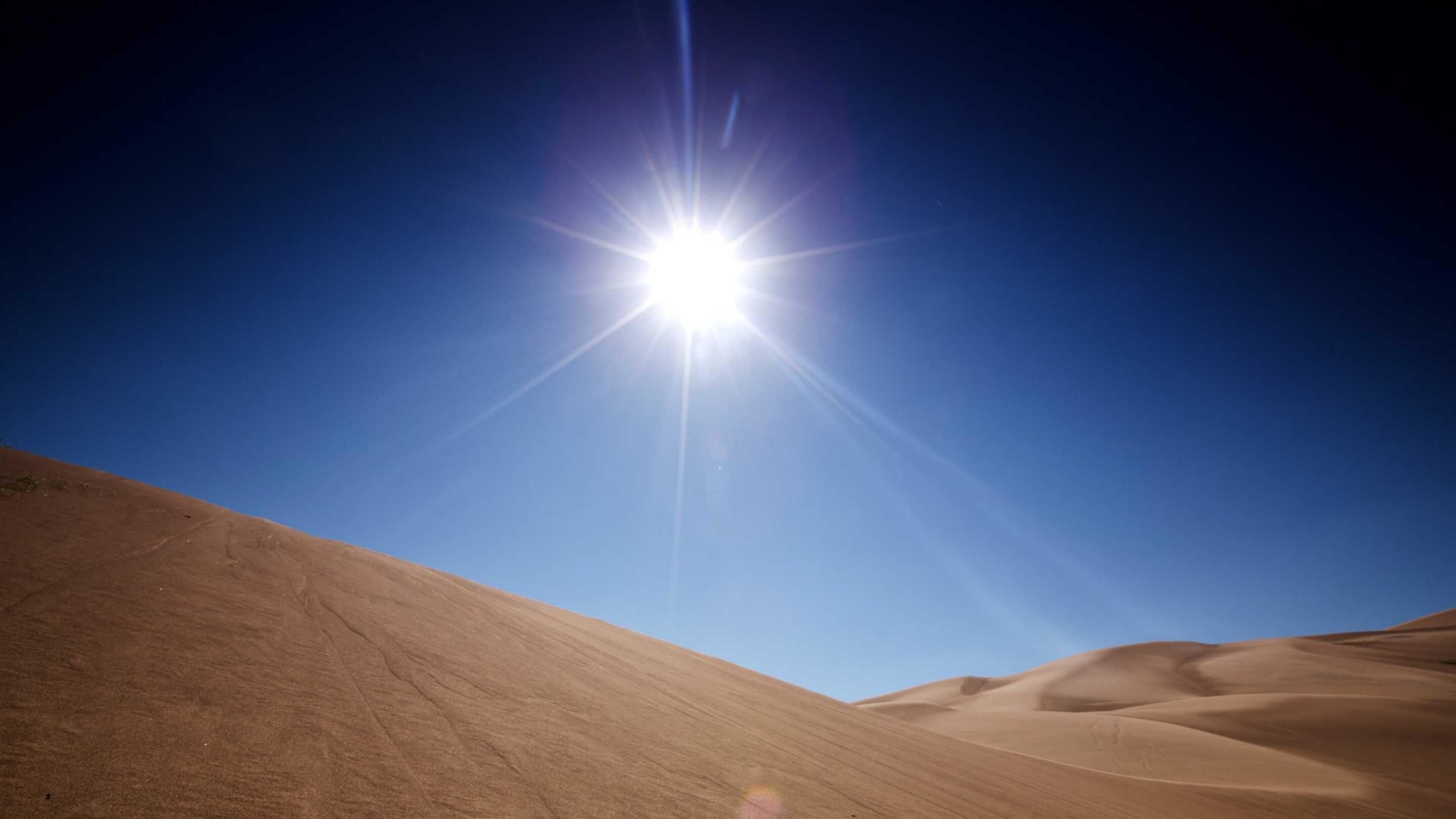 Touch screen a temperatura estesa un sole che splende su una collina sabbiosa