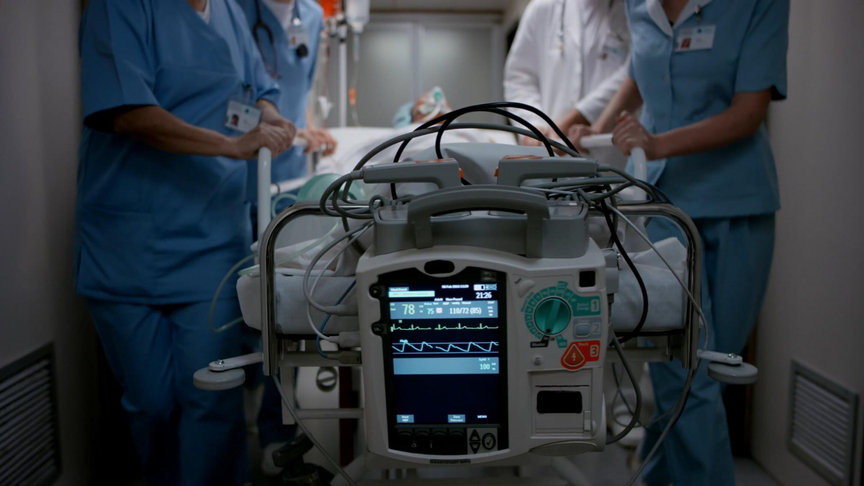 Medical - Robust medical technology medical people in scrubs pushing a medical device