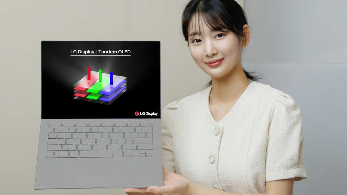 LG 推出 Tandem OLED，一位女士手持笔记本电脑